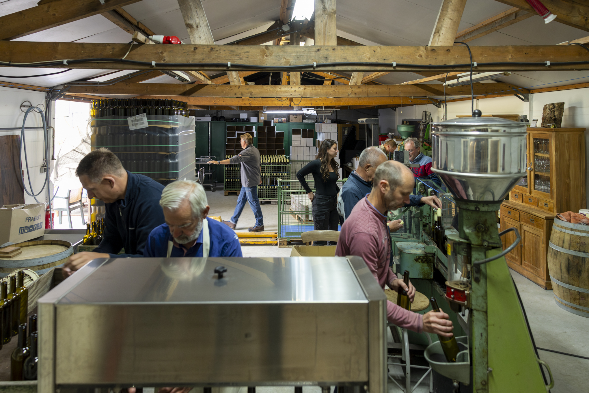 Het hele team zijn wijn aan het bottelen in de schuur